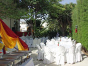 A garden venue with the tables and chairs ready but before decoration