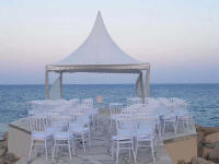 Beach wedding marquee with chairs at sunset for hire