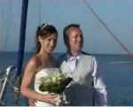 A happy couple pose for a photo on the bow of the boat at their reception